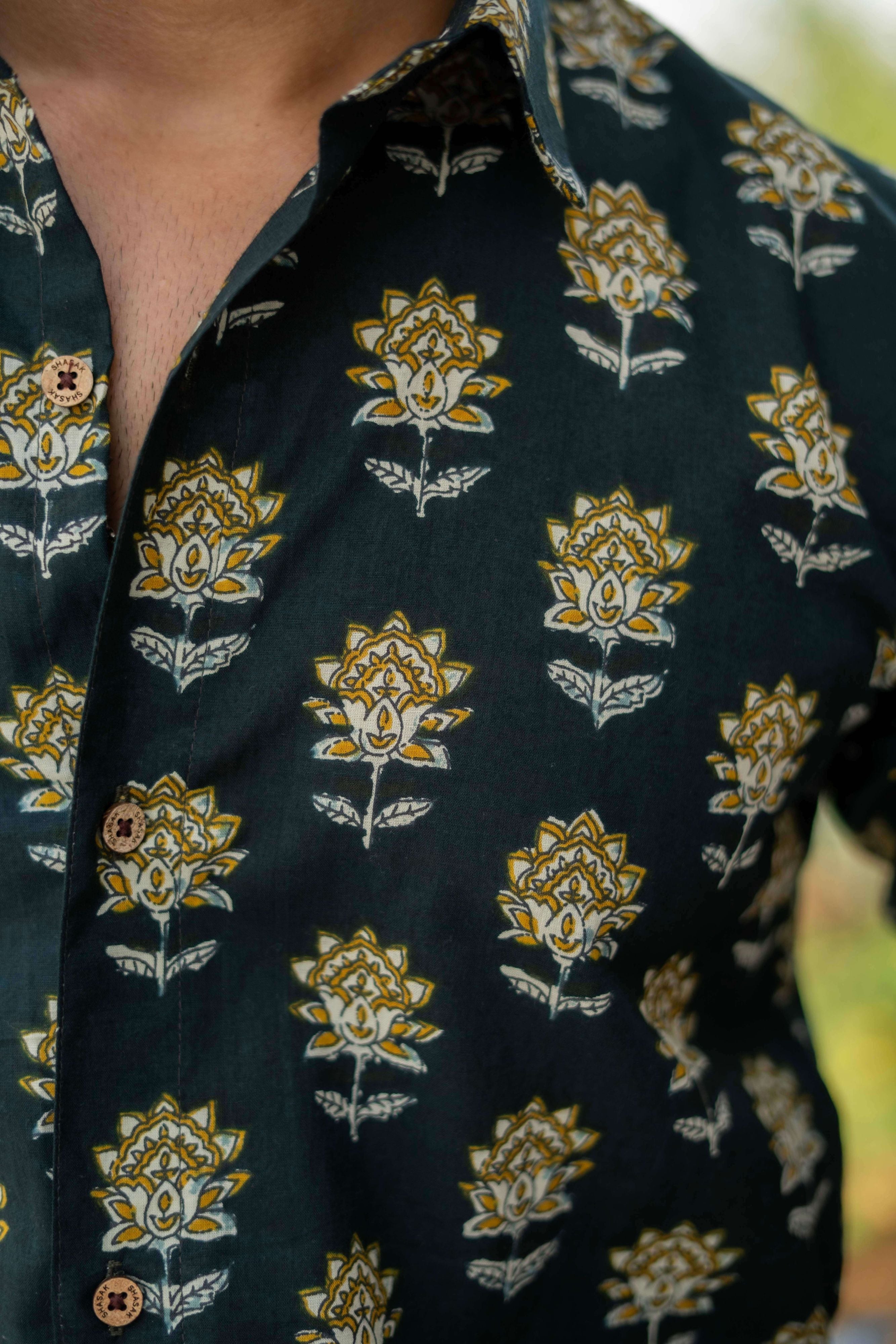 close-up view of castle green shirt featuring yellow and white floral print.