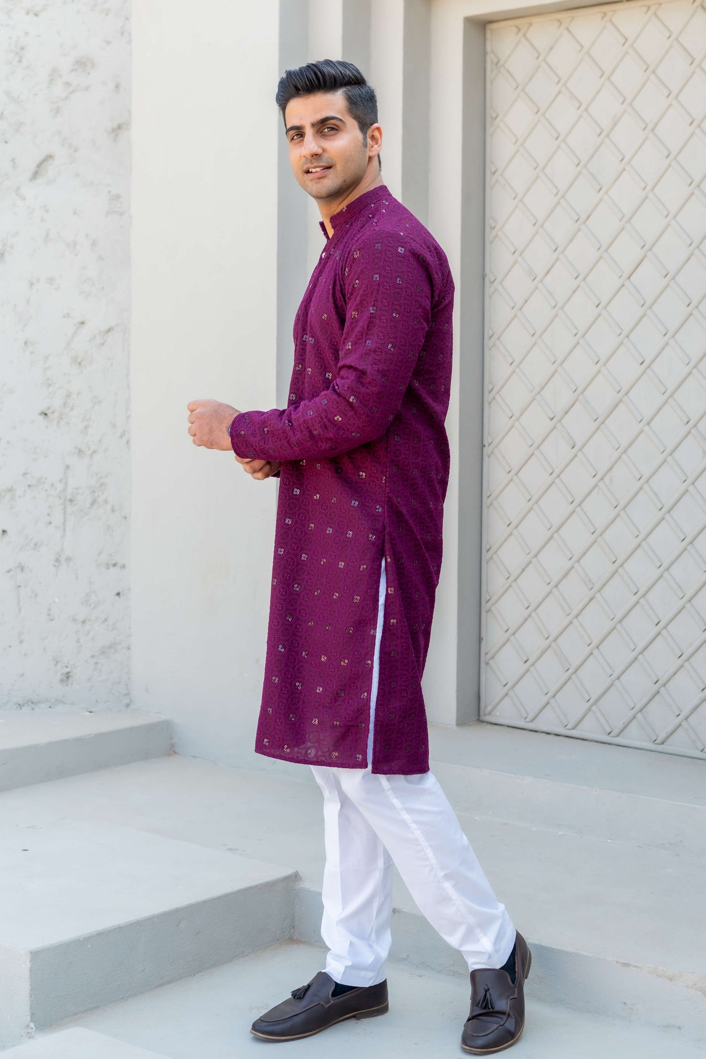 An indian man wearing wine color chikan kari long kurta and white pajama.