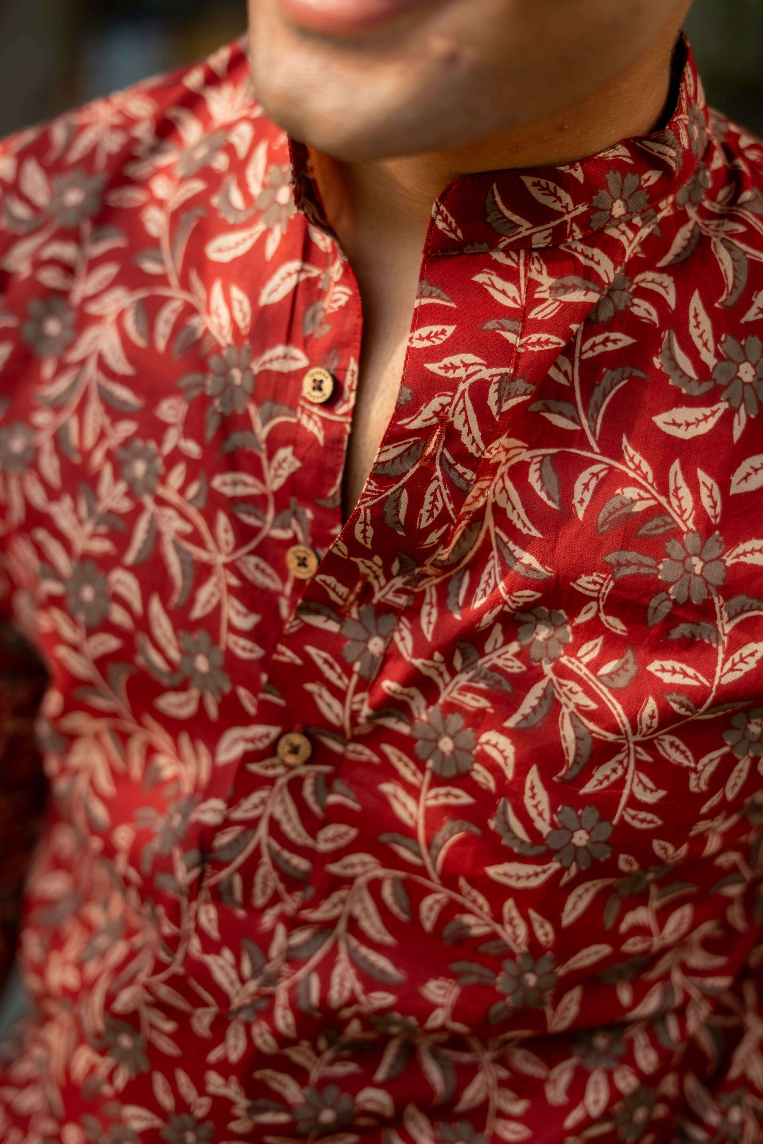 close-up view of maroon short kurta. Featuring wooden buttons.