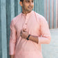An Indian men wearing a pink color short kurta with a black wristwatch