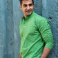 an Indian man wearing green chikan kari kurta for men with a beautiful smile on his face. 