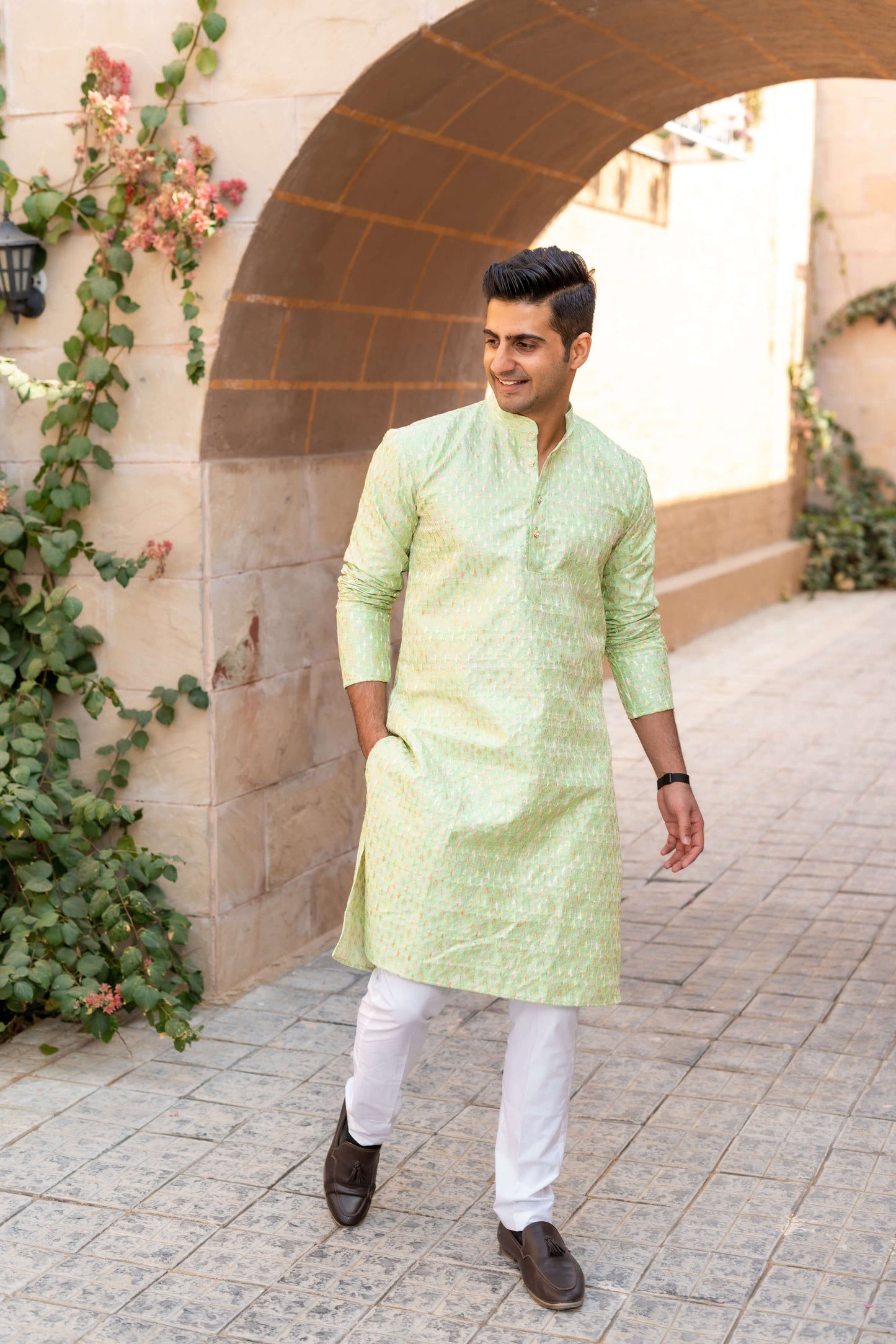 Indian man wearing pist green long kurta with white jeans and black formal shoes.
