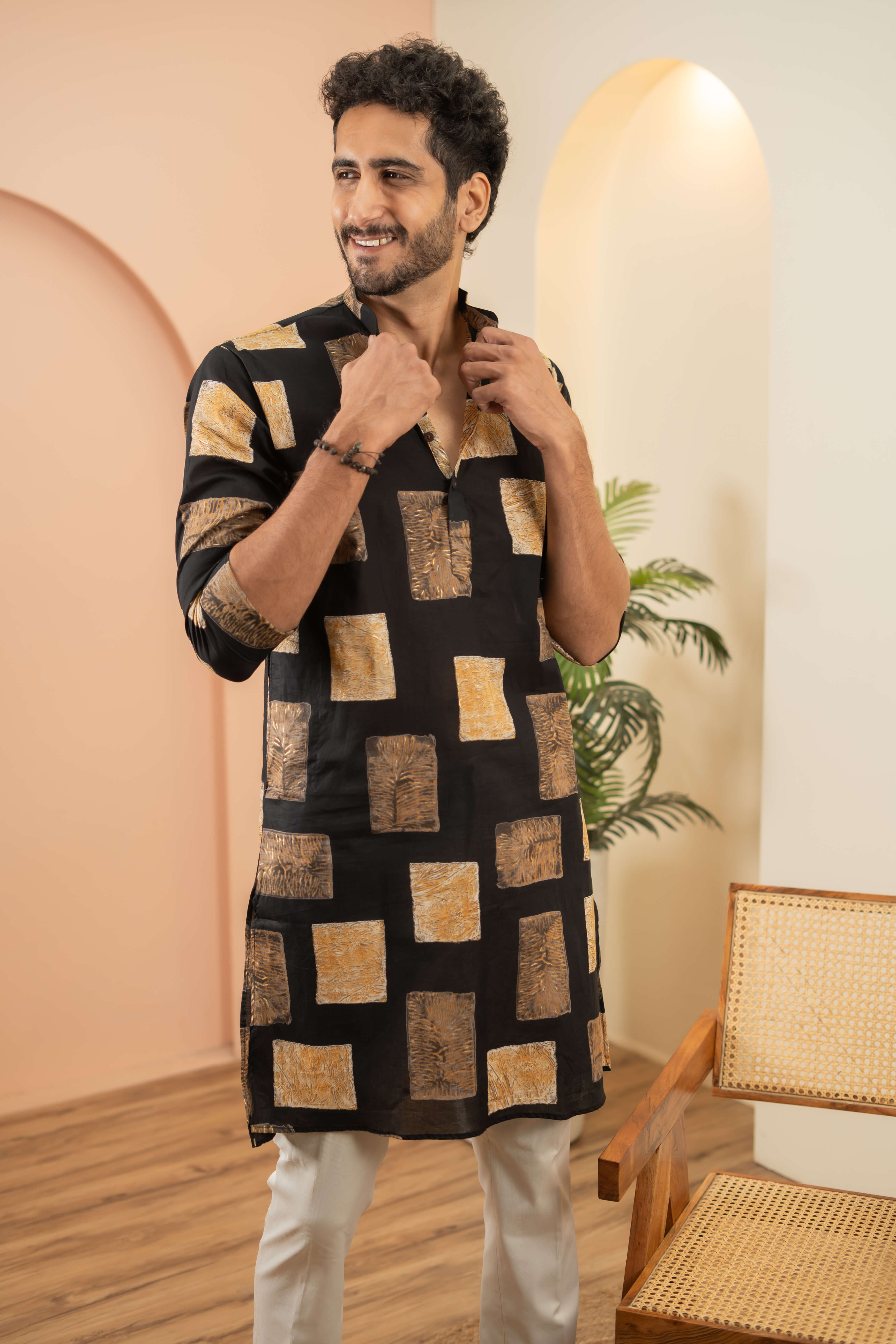 Indian men wearing a black long kurta with white pajama. 