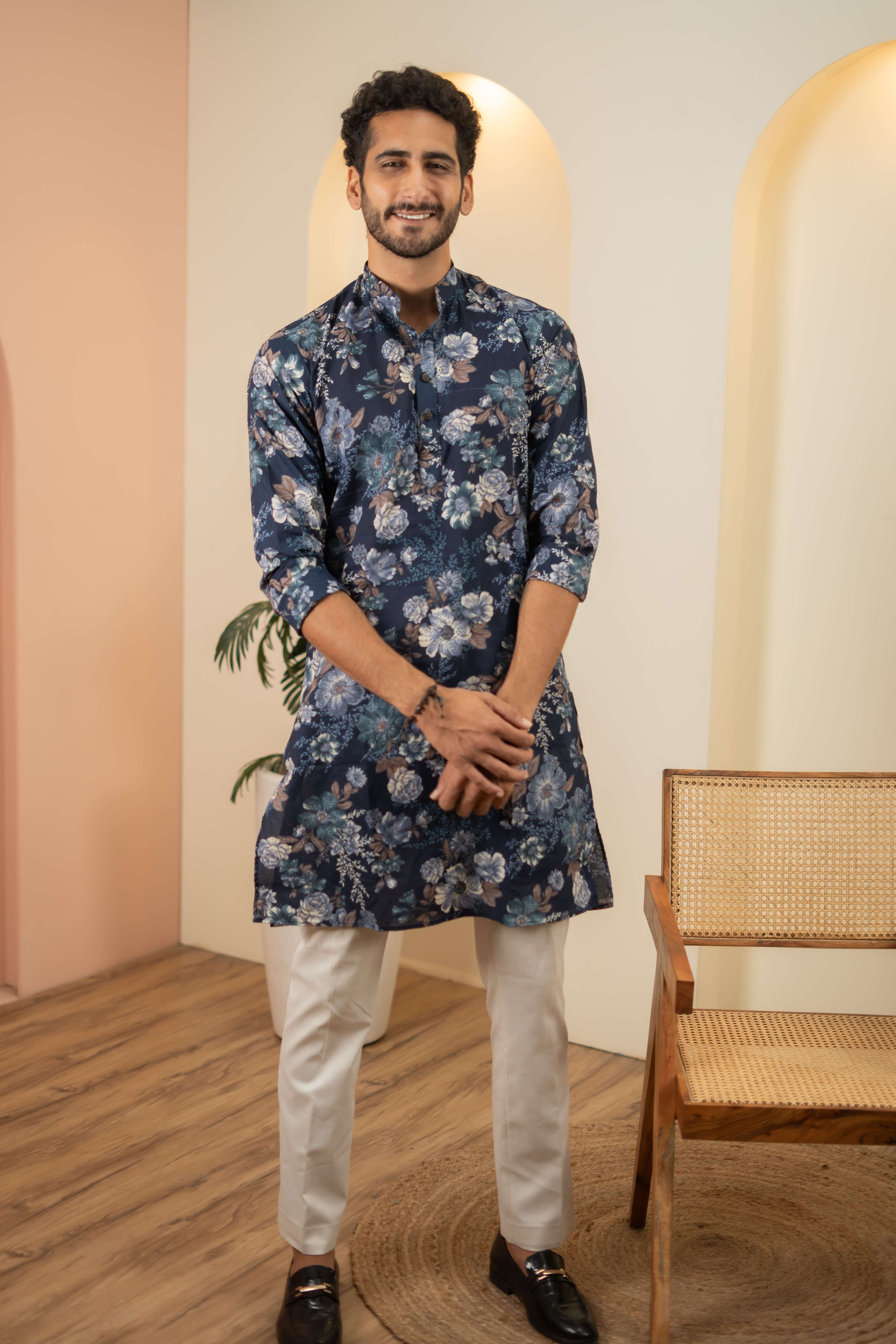 A man wearing a blue floral print kurta, showcasing vibrant patterns and traditional attire.