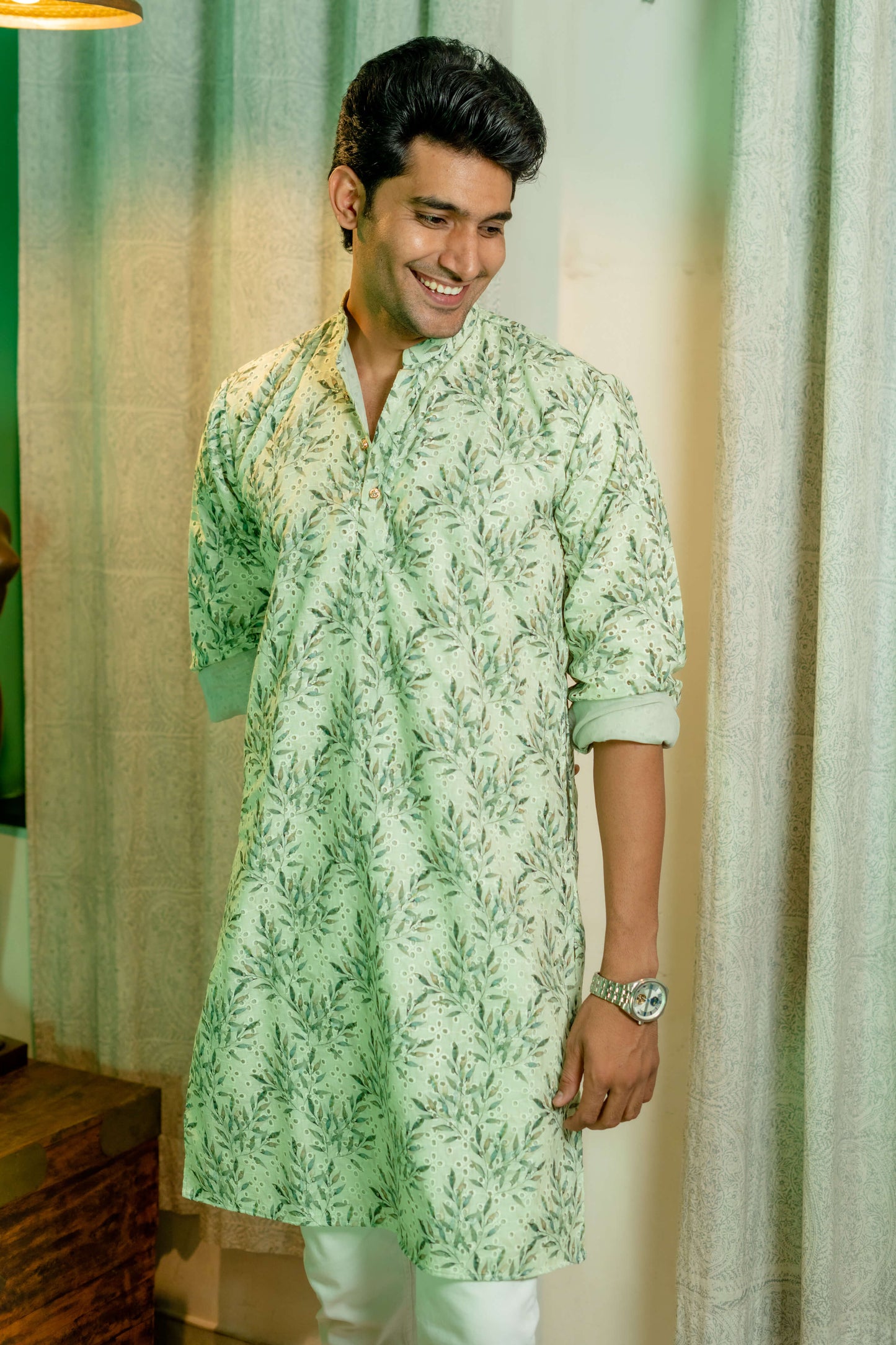 An Indian man wearing green chikan kari long kurta 