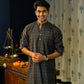 An India Man Wearing a Black Long With a Geometric Print Getting