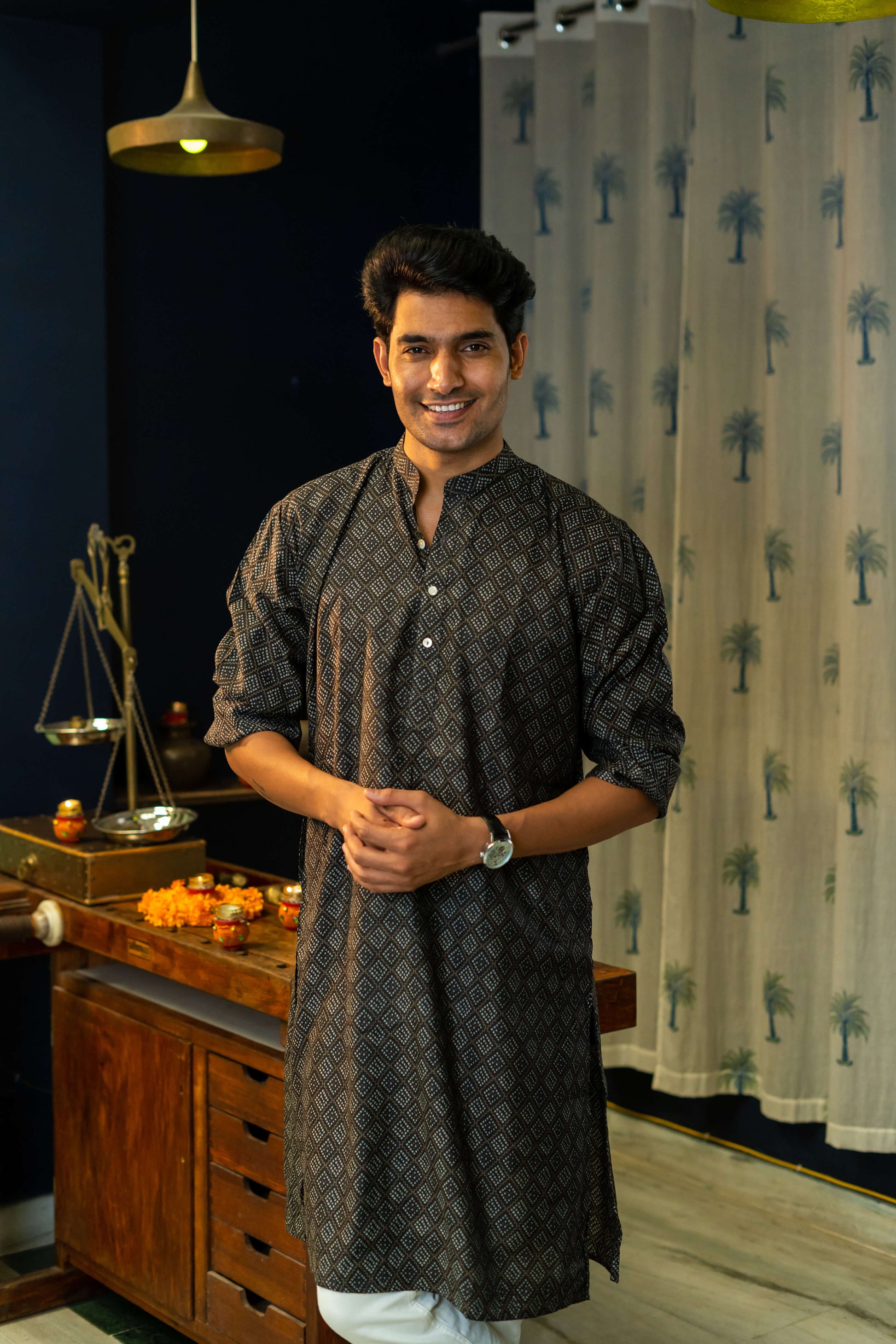 An India Man Wearing a Black Long With a Geometric Print Getting