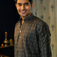 An Smiling India Man Wearing a Black Long With a Geometric Print