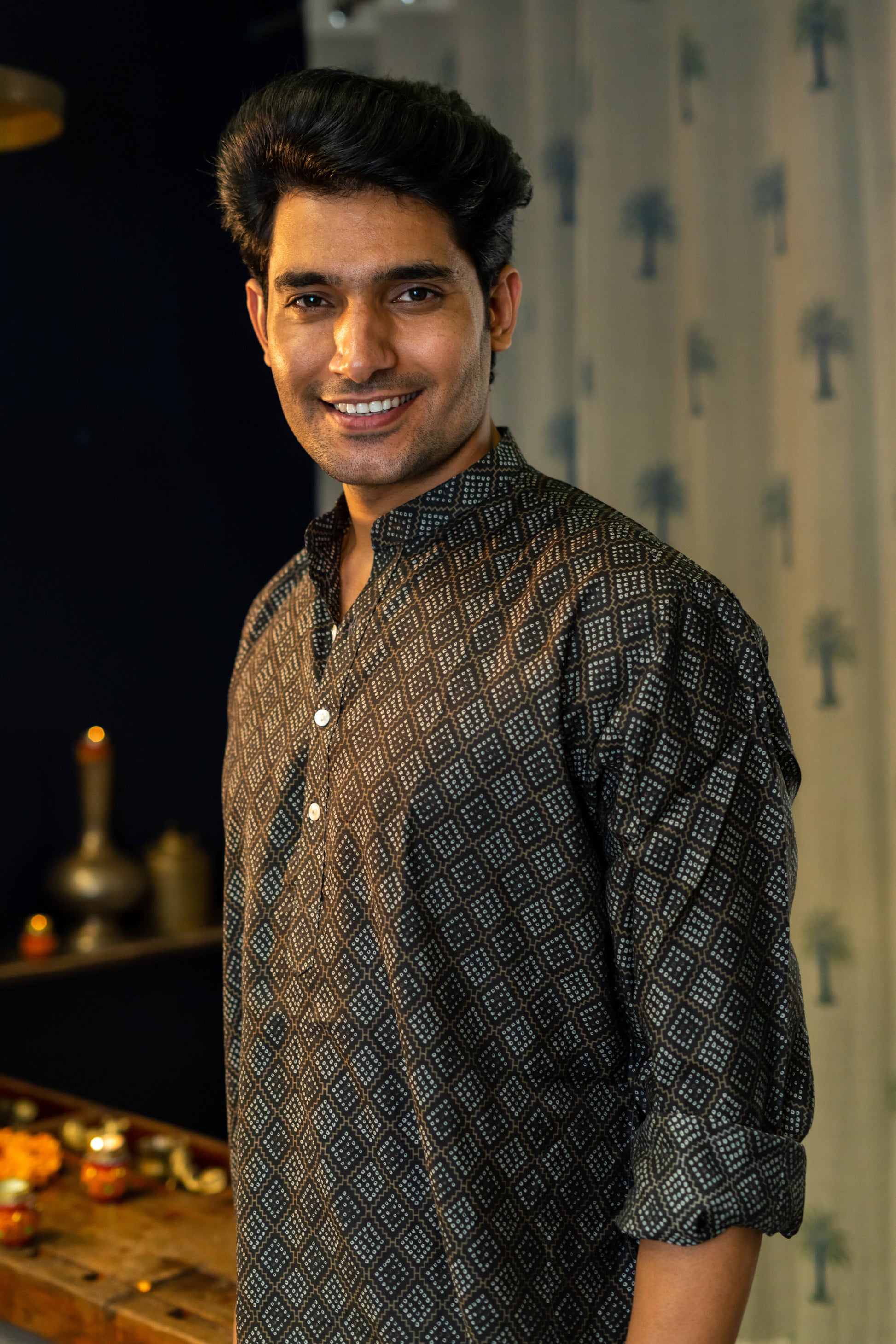 An Smiling India Man Wearing a Black Long With a Geometric Print