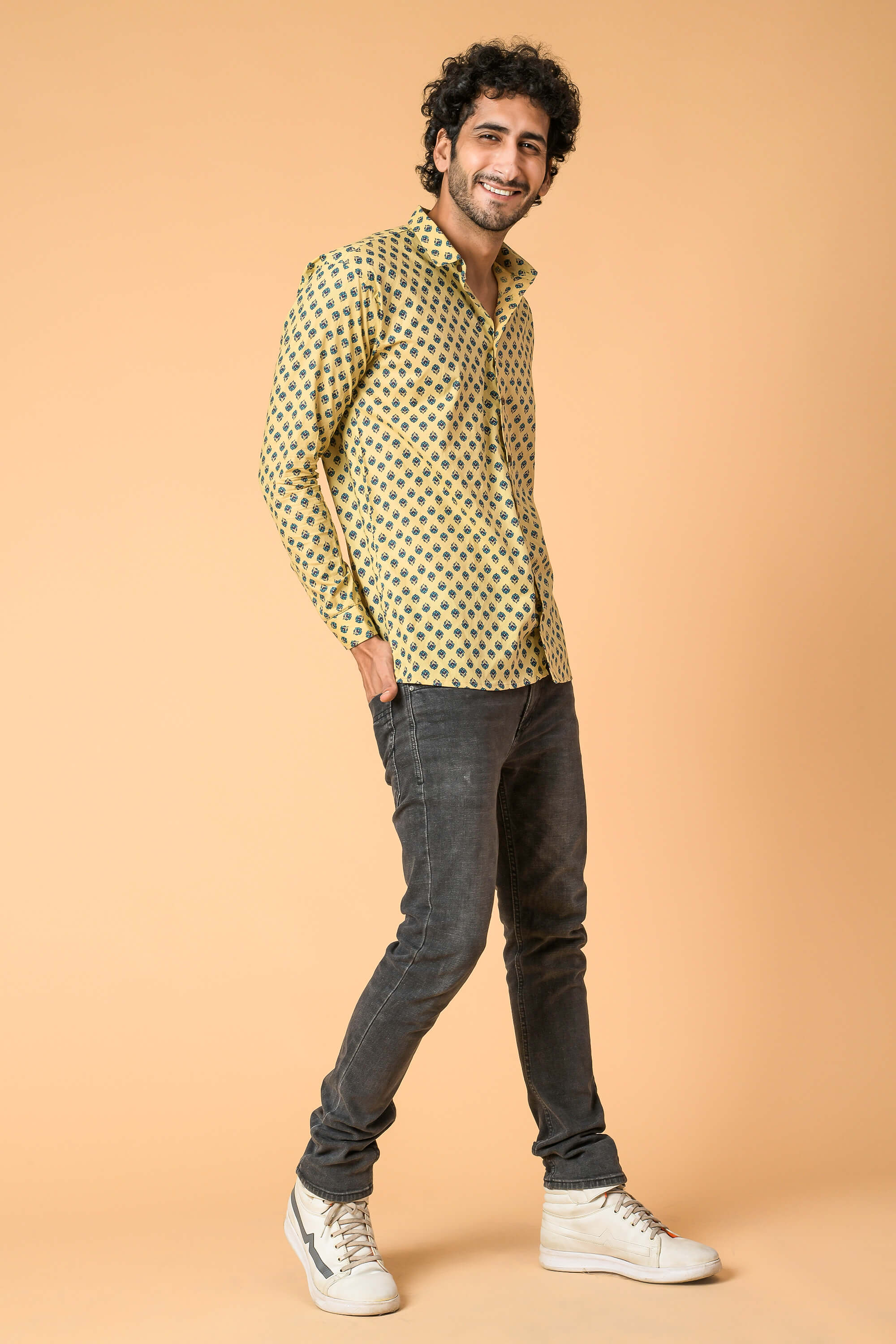 beige color butti printed shirt worn by a Indian man with black deniim and white shoes. 